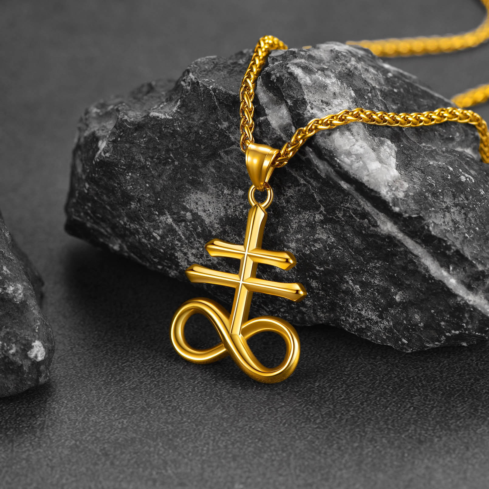 Gold Leviathan Cross necklace on stone background aesthetic shot