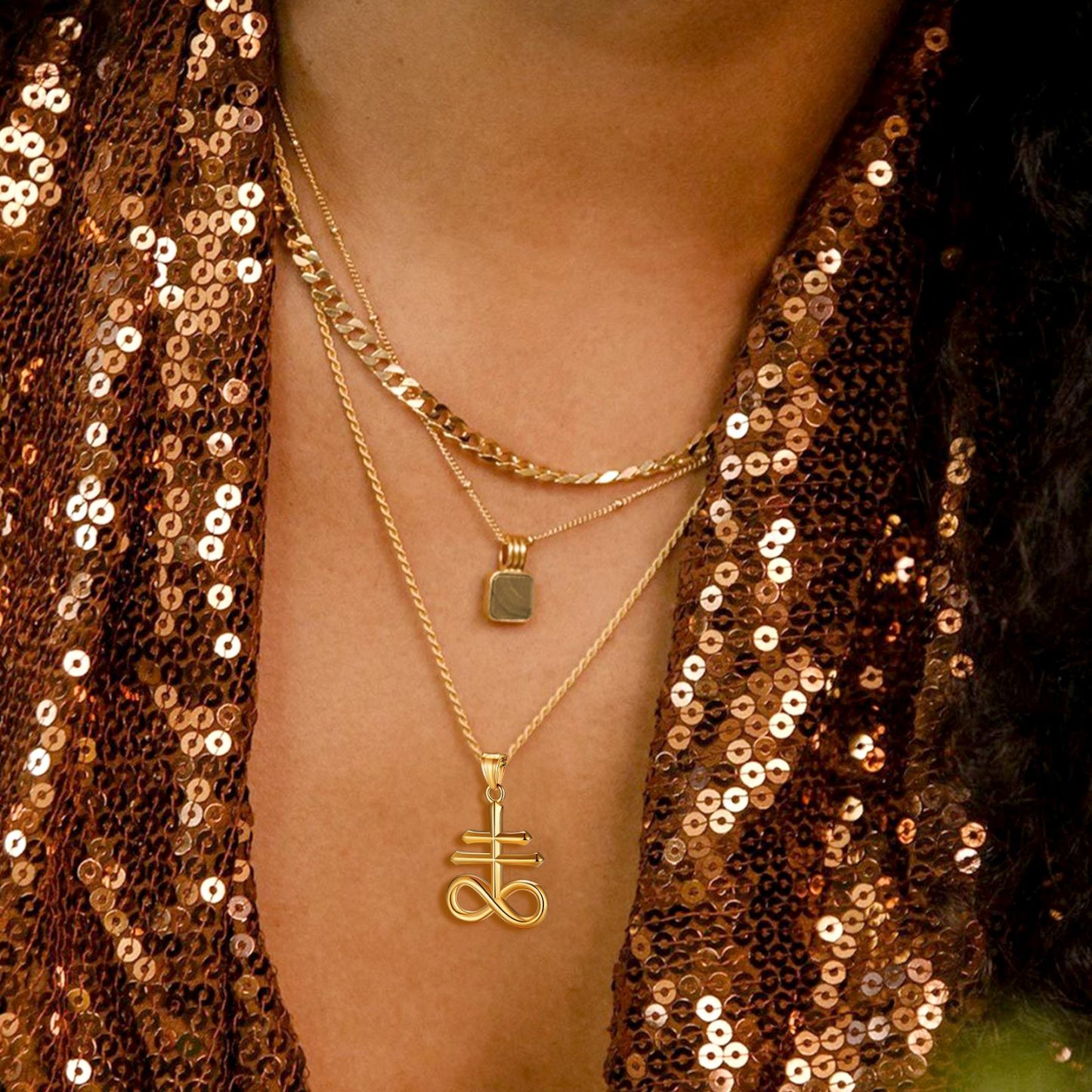 Woman wearing gold Leviathan Cross pendant layered necklaces