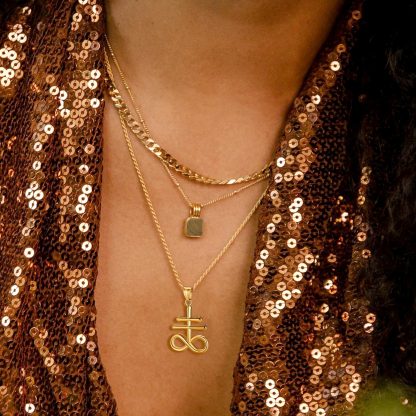 Woman wearing gold Leviathan Cross pendant layered necklaces