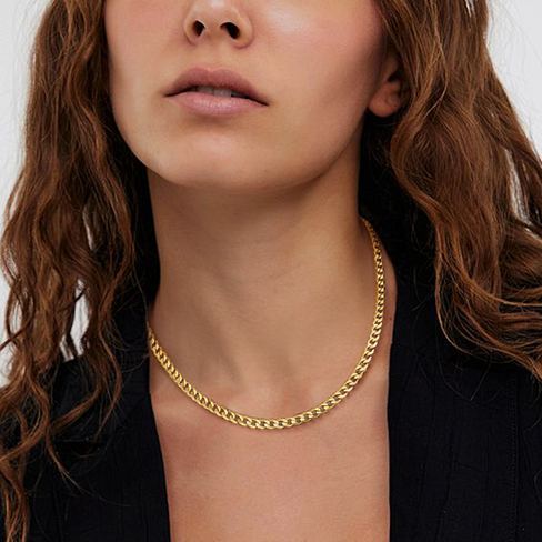 Woman wearing gold Cuban chain necklace minimalist style