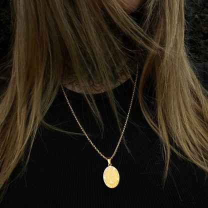 Woman wearing gold Saint Christopher necklace, minimalist religious pendant necklace
