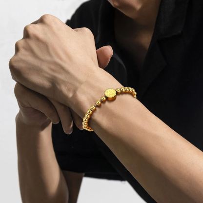 gold beads bracelet on men wrist