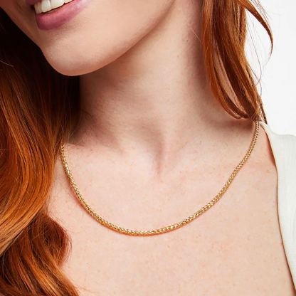 Woman wearing thin gold wheat chain necklace