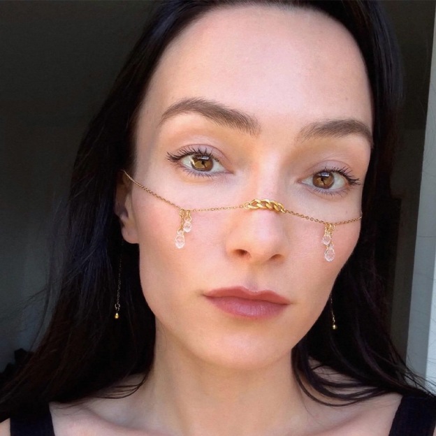 Teardrop face chain with an understated, cool aesthetic.