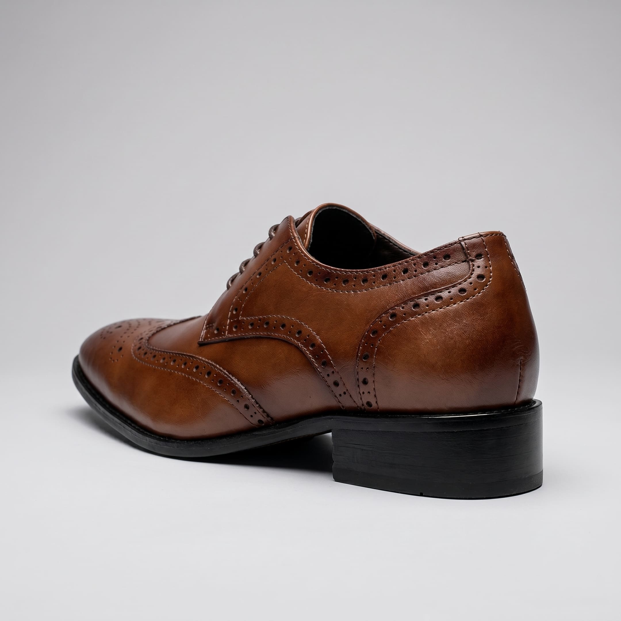 FORCIANO BROGUE brown premium leather elevator dress shoe shown from the rear three-quarter angle with brogue trim and black heel.
