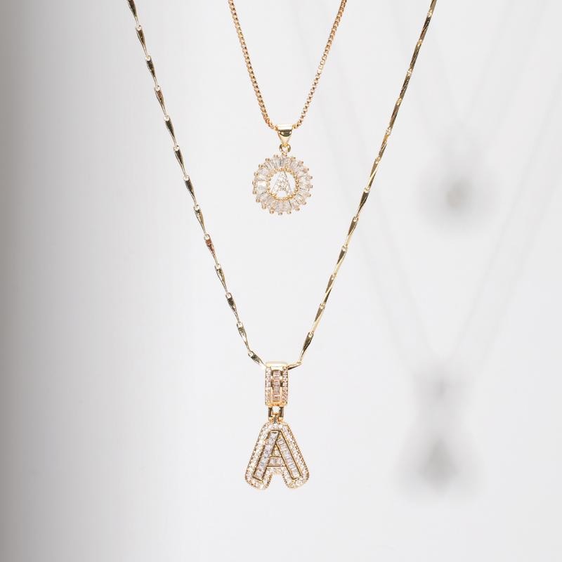 Warstwowa biżuteria – naszyjnik z inicjałem łączony z innymi łańcuszkami