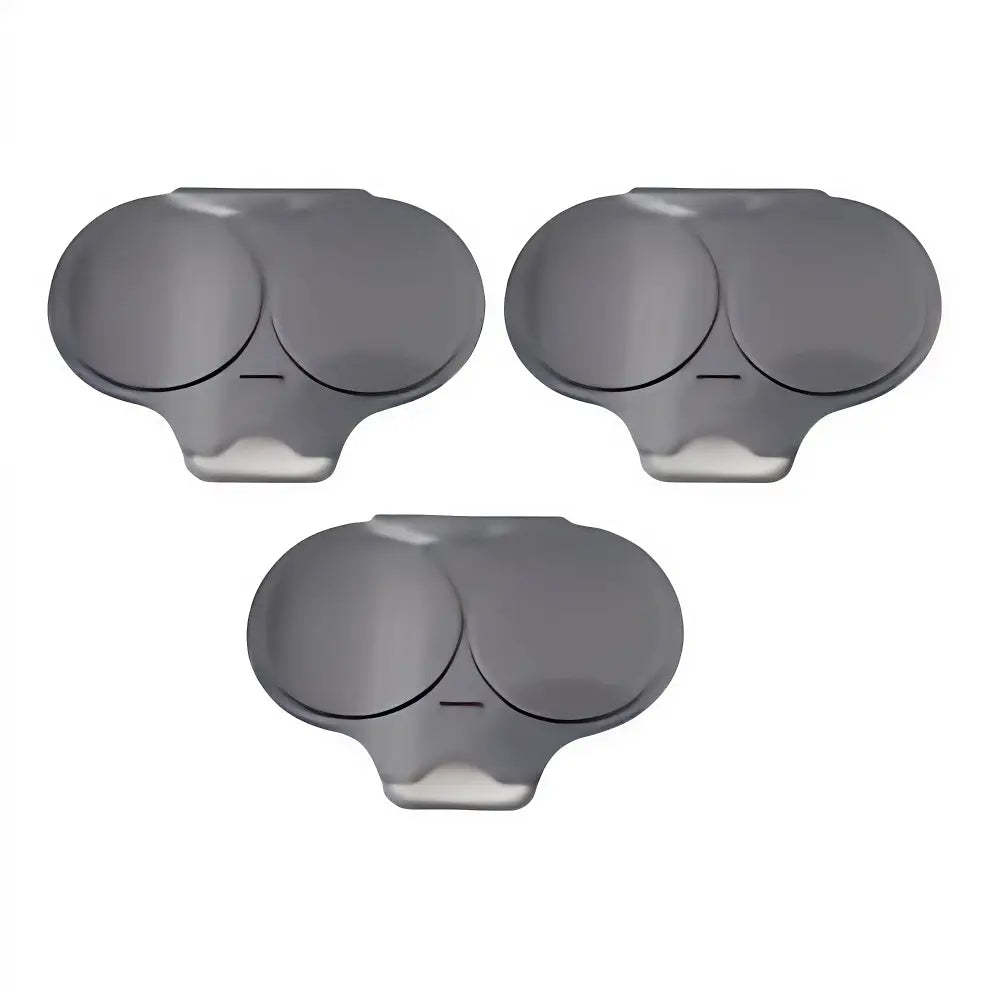 Three dark gray plastic replacement caps with circular inserts, arranged on a plain white background.