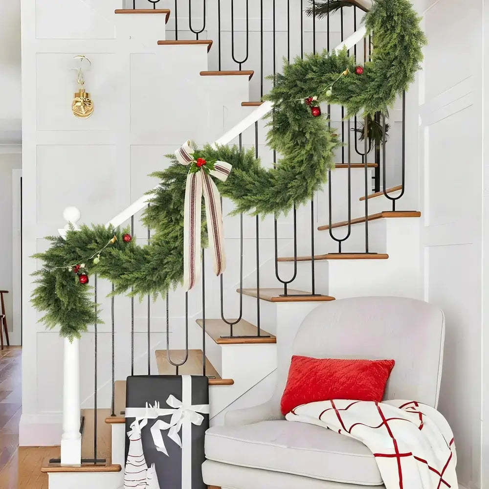 Decorative Christmas garland on a staircase with a white chair and gift bag in the foreground.