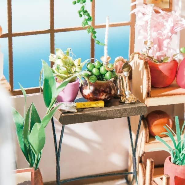 Detailed view of miniature potted plants, paper flowers, and gardening tools inside the dollhouse.