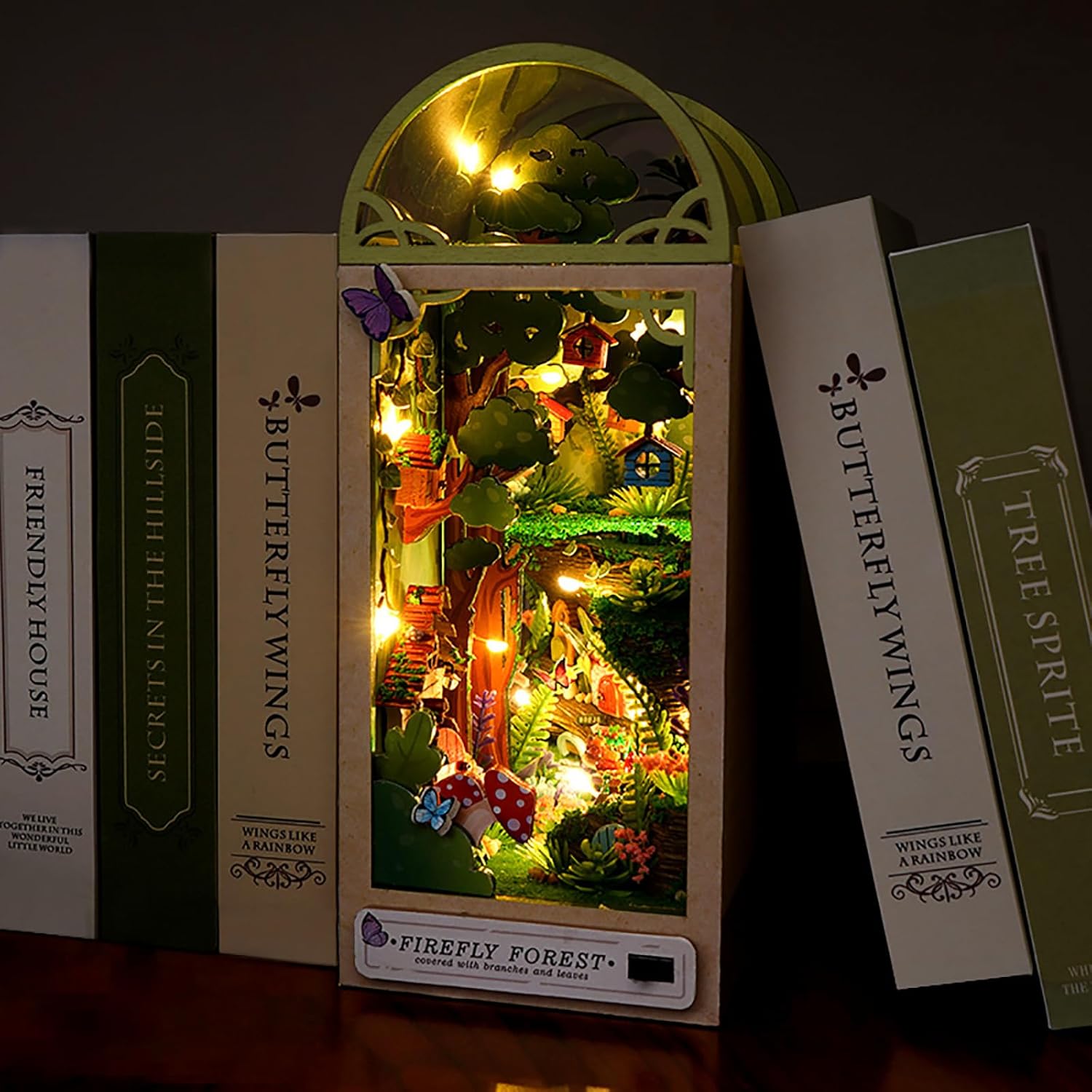 Firefly Forest DIY book nook kit illuminated with warm LED lights, displayed as a bookshelf insert.
