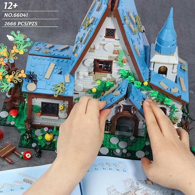 Hands assembling the blue roof of the Magic Stone House 2666 piece building set No.66041.