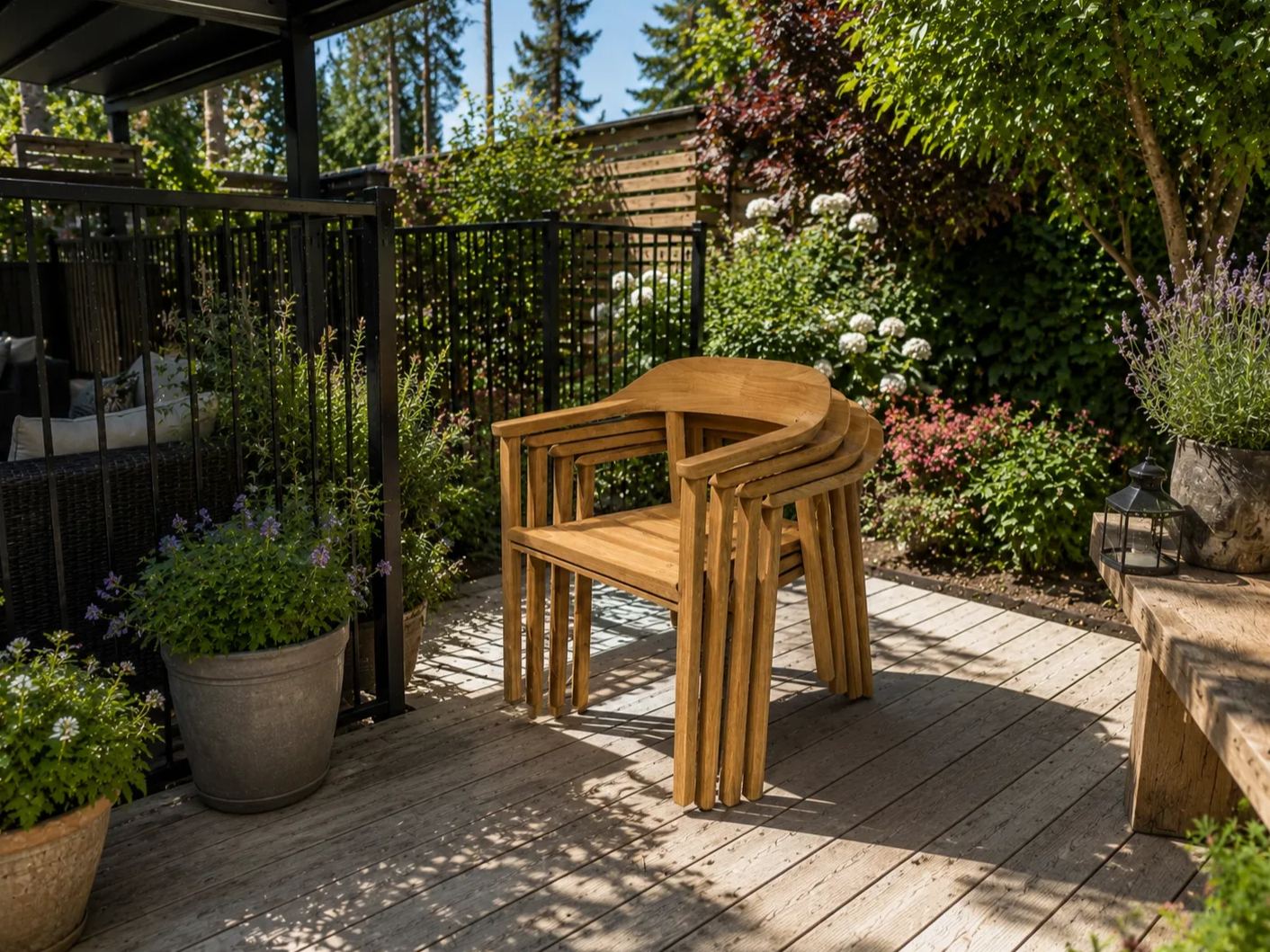 Stacked Veluta Curve FSC® certified teak outdoor dining chairs on a contemporary garden deck, ideal for patio dining