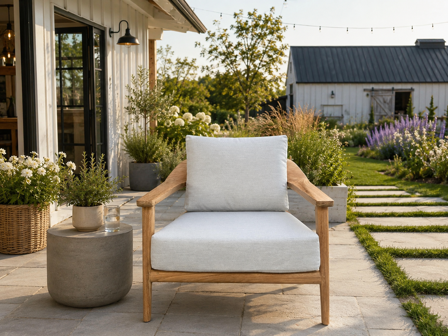 Veluta Curve FSC® certified solid teak outdoor lounge armchair creating a contemporary garden seating area with premium cushions