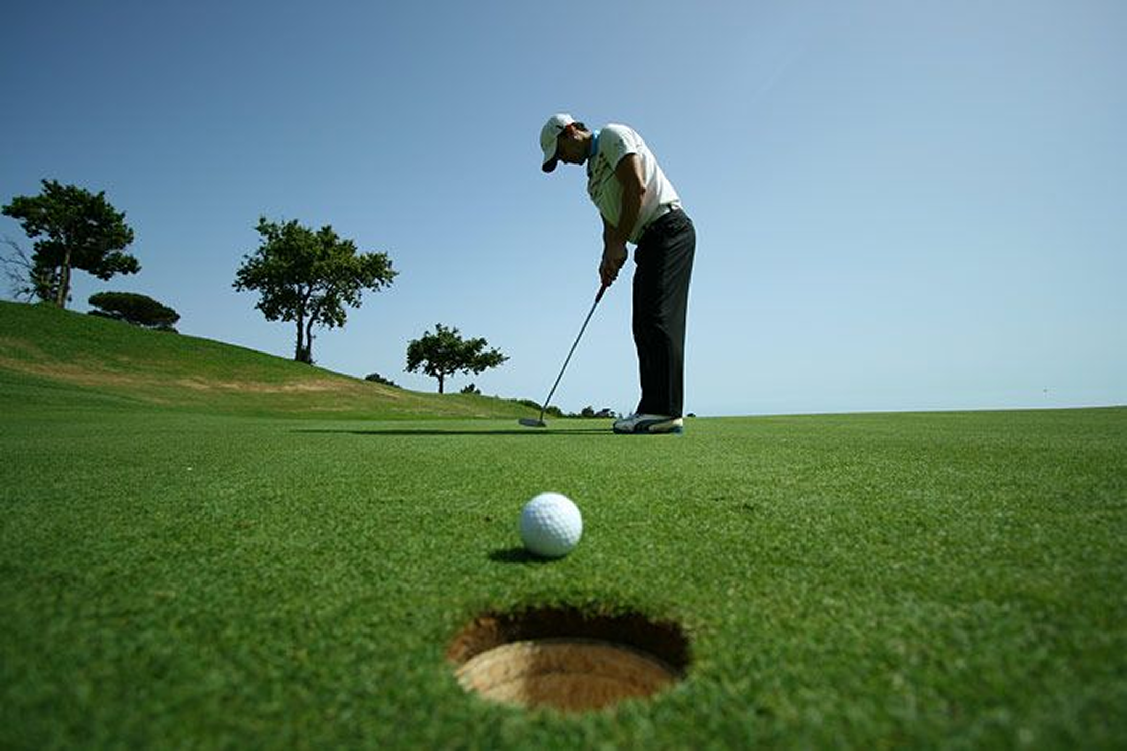 Golfer Taking a Putt on the Green with the Ball Near the Hole