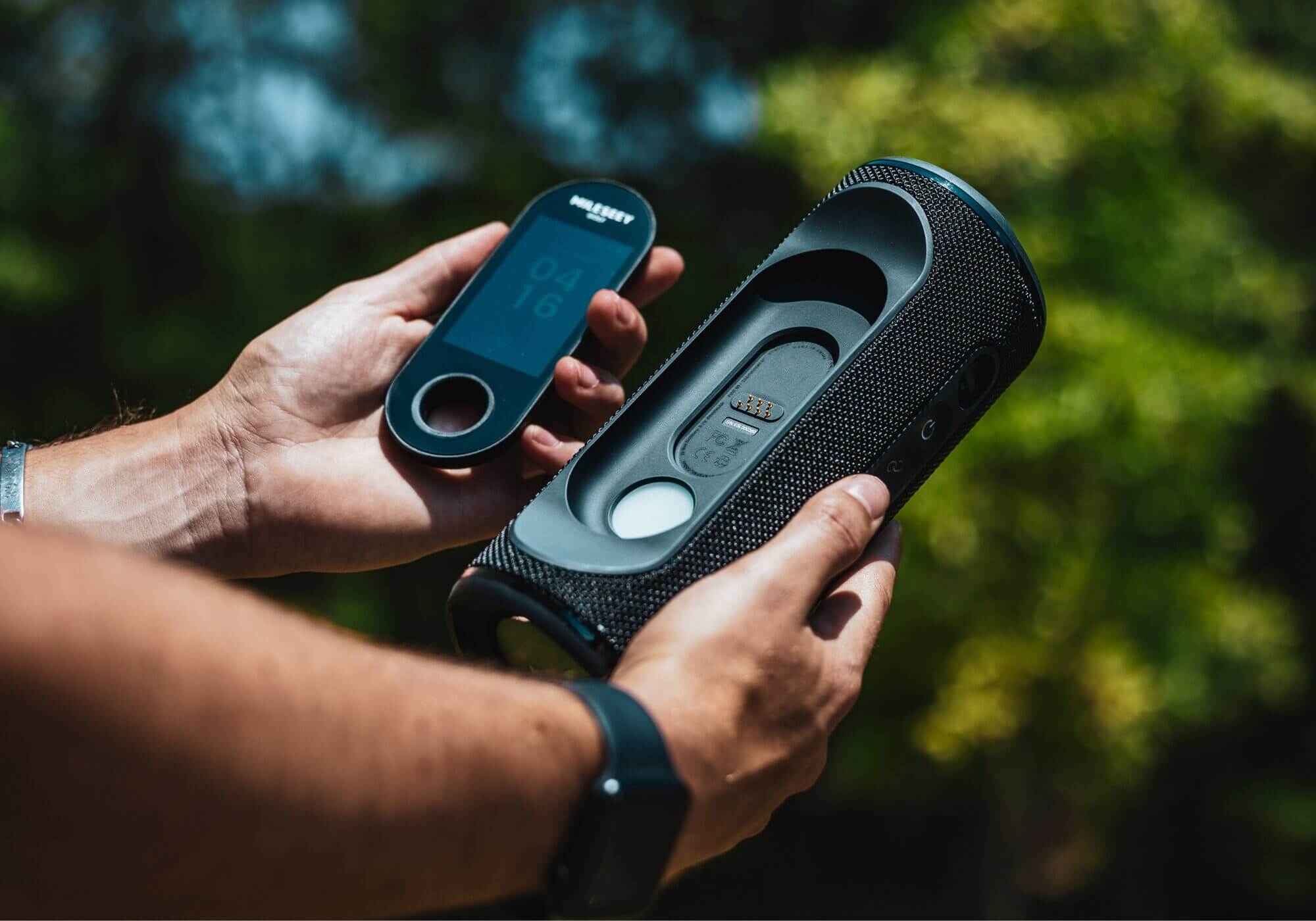The MyGolfSpy editor holding a Mileseey Golf GeneSonic Pro detachable golf gps speaker