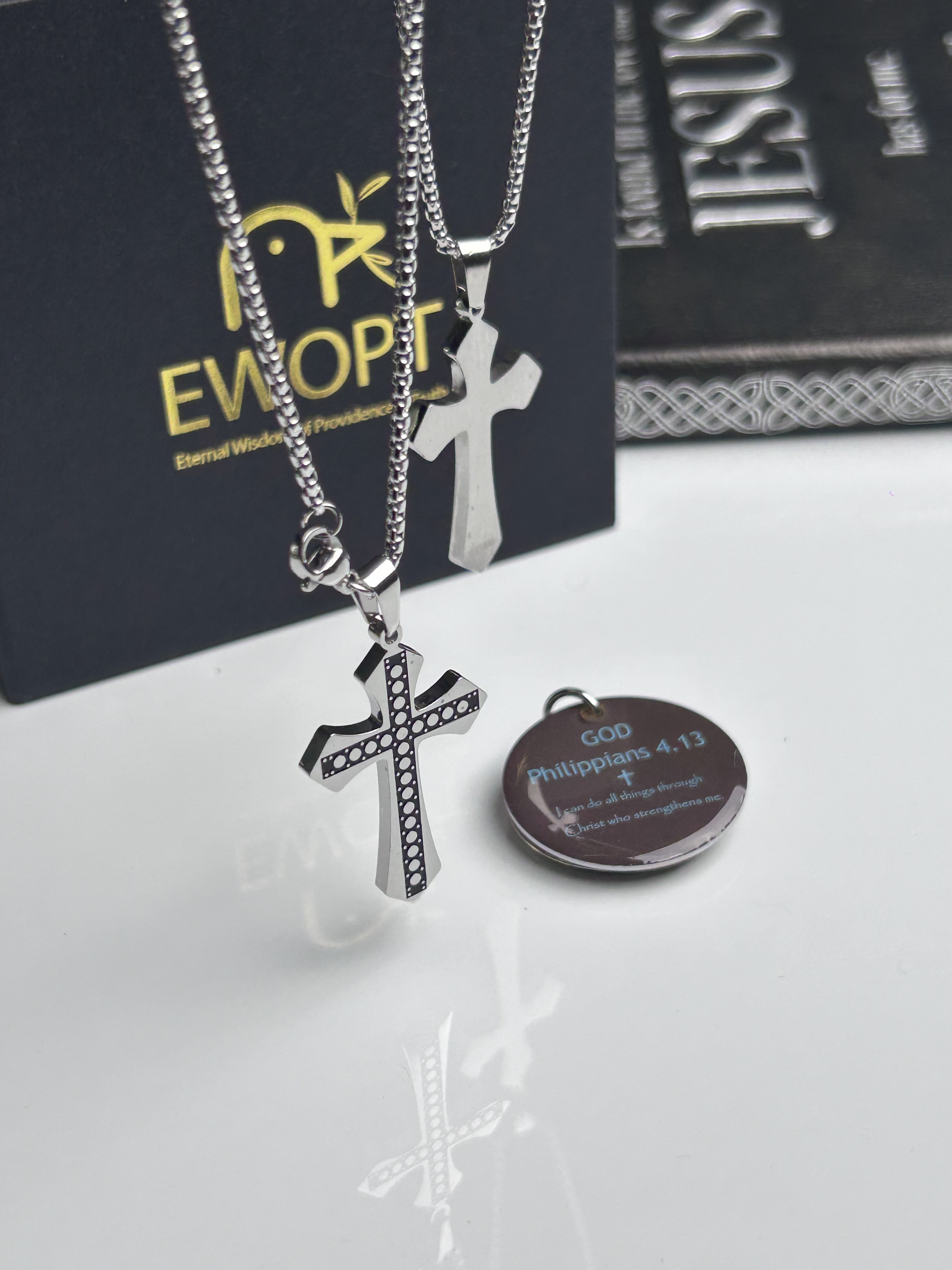 Showcasing a silver cross necklace with a detailed carbon fiber inlay, this piece marries classic religious symbolism with modern technology through an NFC-enabled keychain that presents daily Bible verses, enhancing both spirituality and style.