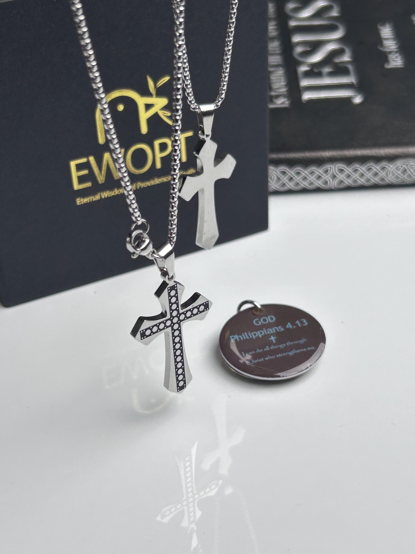 Showcasing a silver cross necklace with a detailed carbon fiber inlay, this piece marries classic religious symbolism with modern technology through an NFC-enabled keychain that presents daily Bible verses, enhancing both spirituality and style.