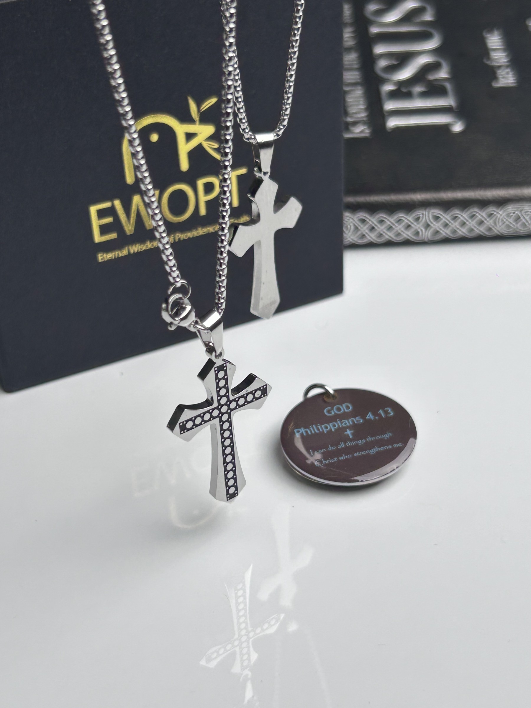 Showcasing a silver cross necklace with a detailed carbon fiber inlay, this piece marries classic religious symbolism with modern technology through an NFC-enabled keychain that presents daily Bible verses, enhancing both spirituality and style.
