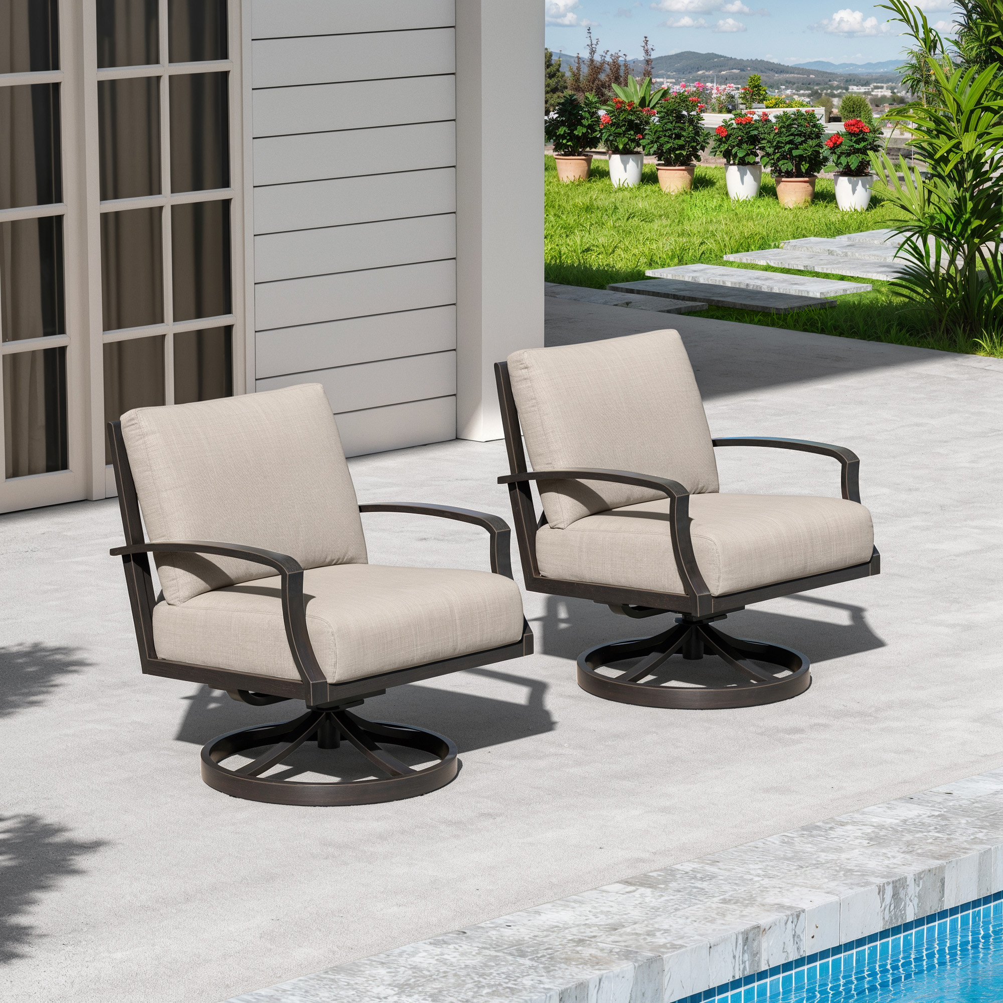 Two wide cushioned swivel chairs on a patio near a pool with greenery and flowers-Seehill