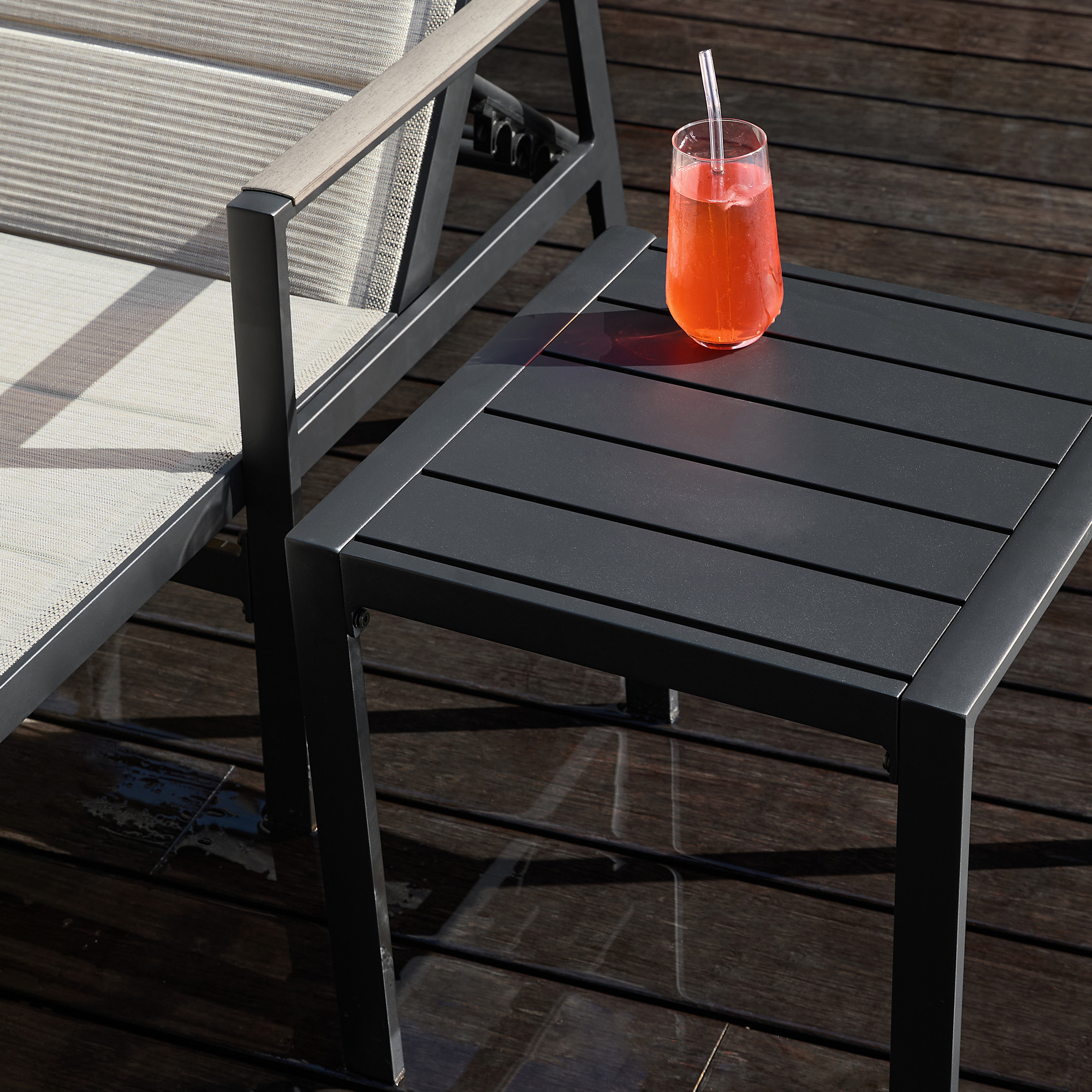 Explore the modern black outdoor side table with a sleek design and drink placement of the graceful patio set. - Seehill