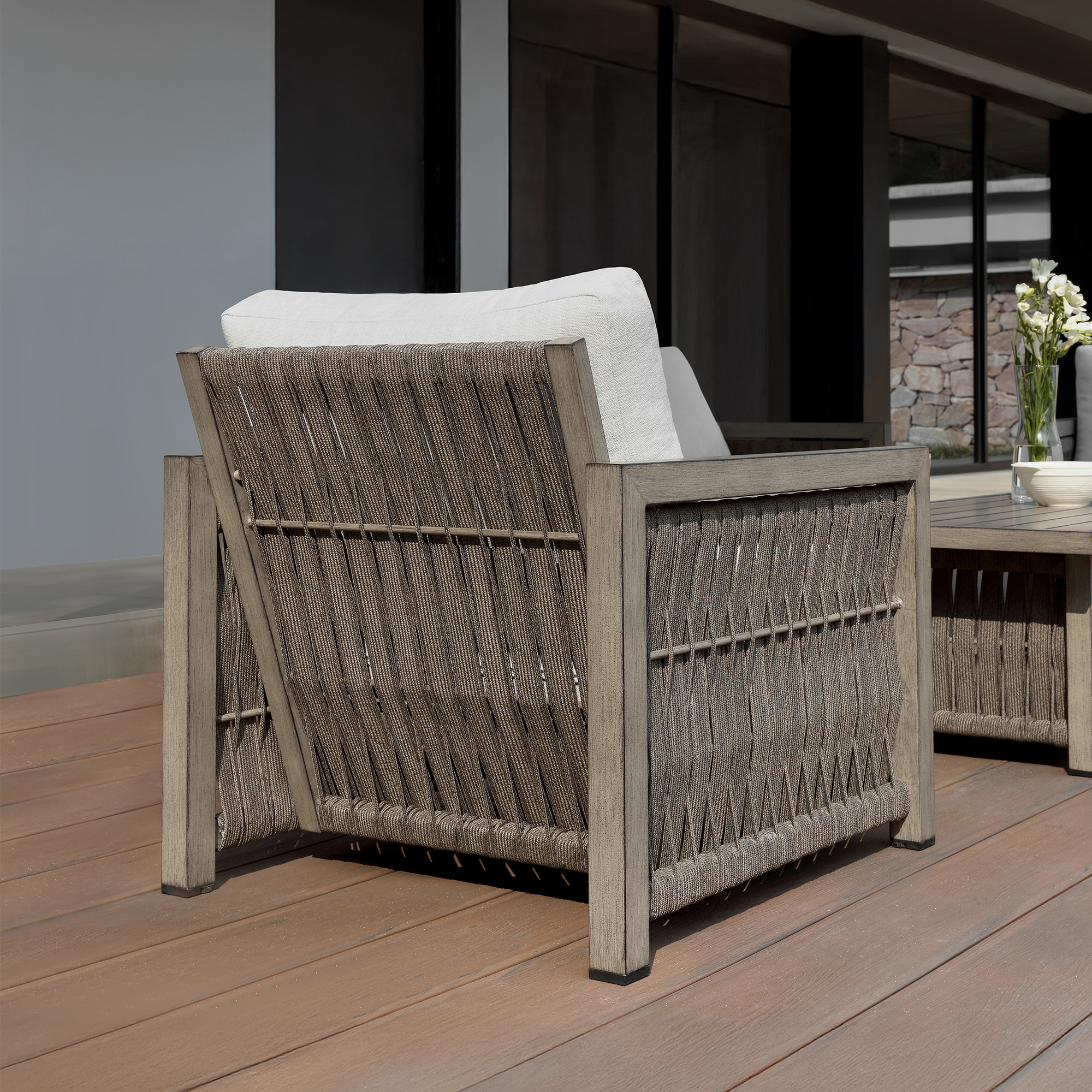 A sophisticated Oversize Rope Weave Outdoor Sofa featuring a modern outdoor armchair with a woven back. - Seehill