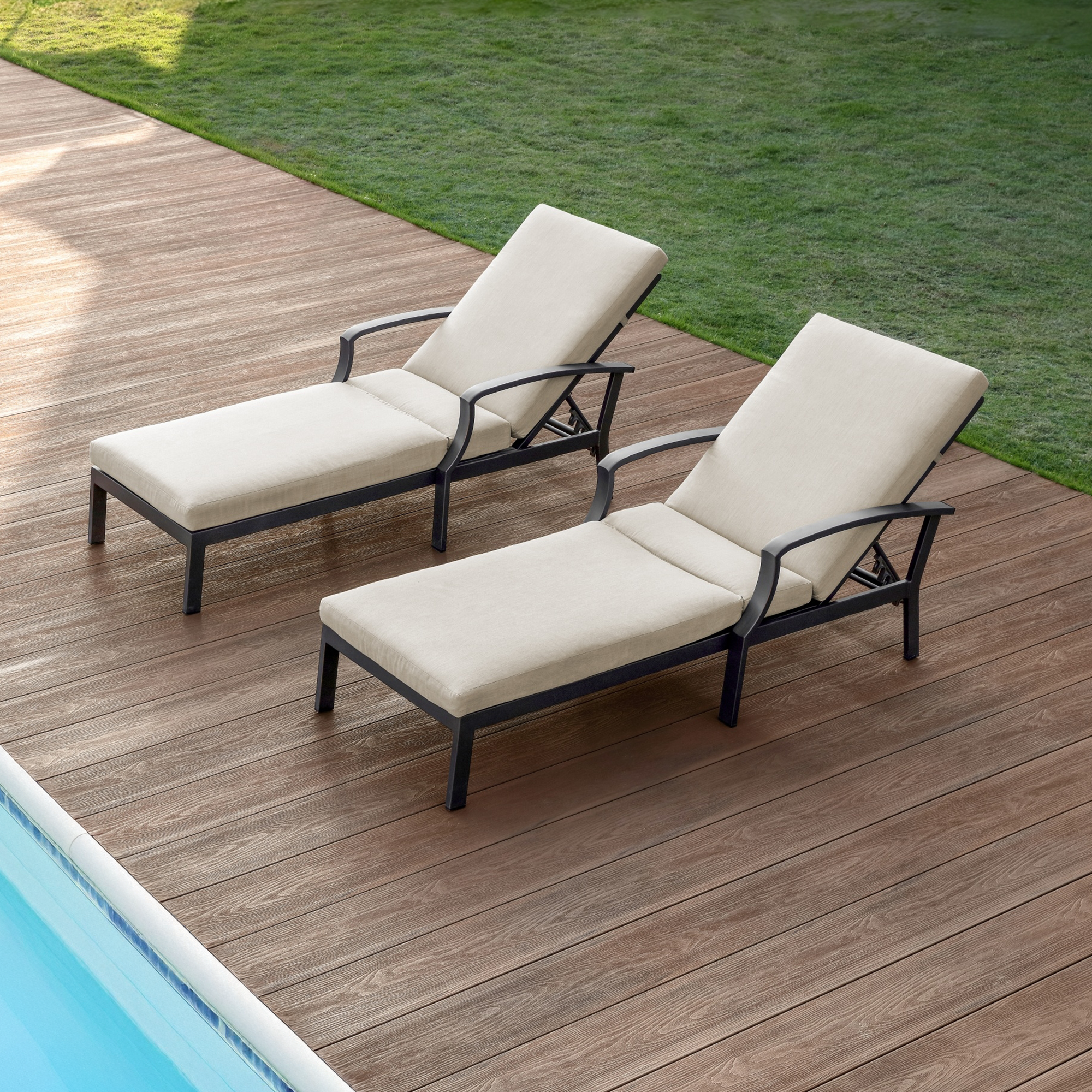 Two beige cushioned outdoor lounge chairs with adjustable backs by a poolside deck-Seehill