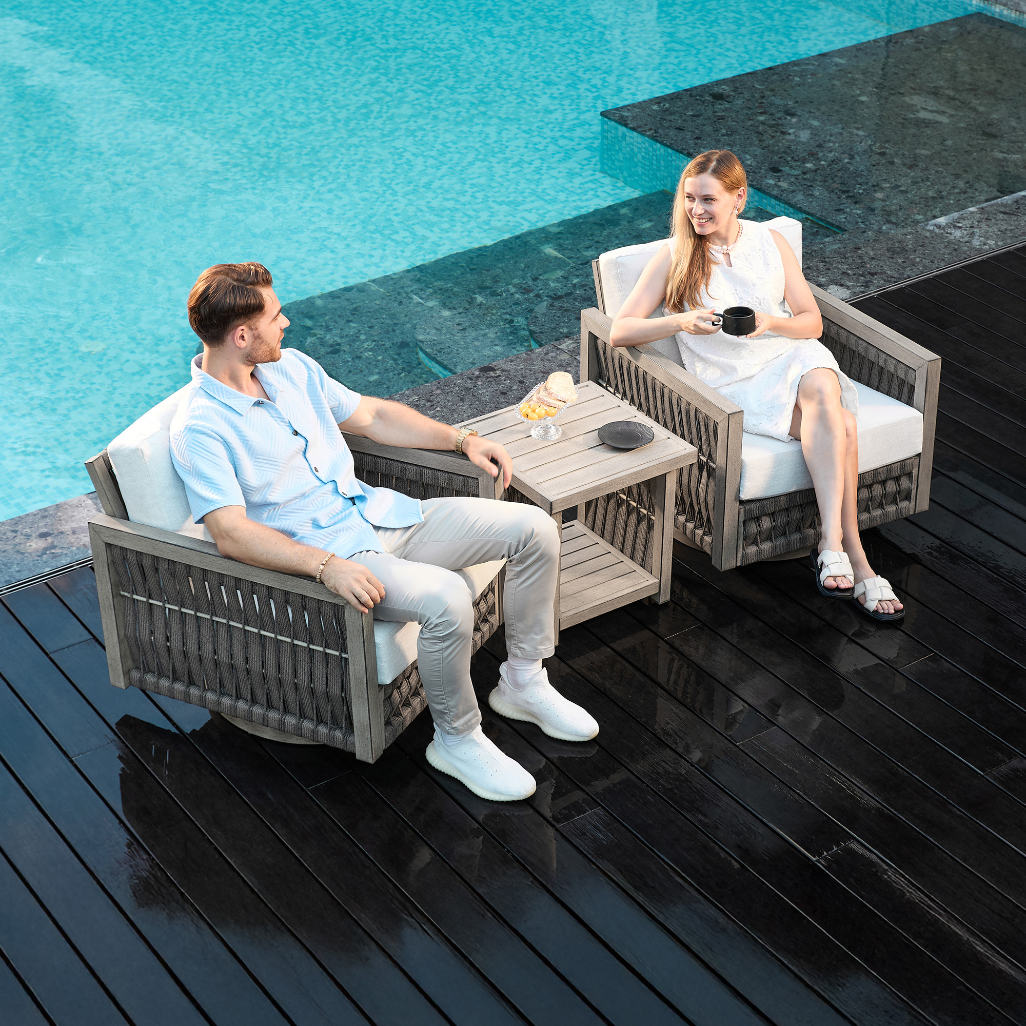 Highlighting the modern gray rattan patio chairs with white cushions of this refined outdoor patio. - Seehill