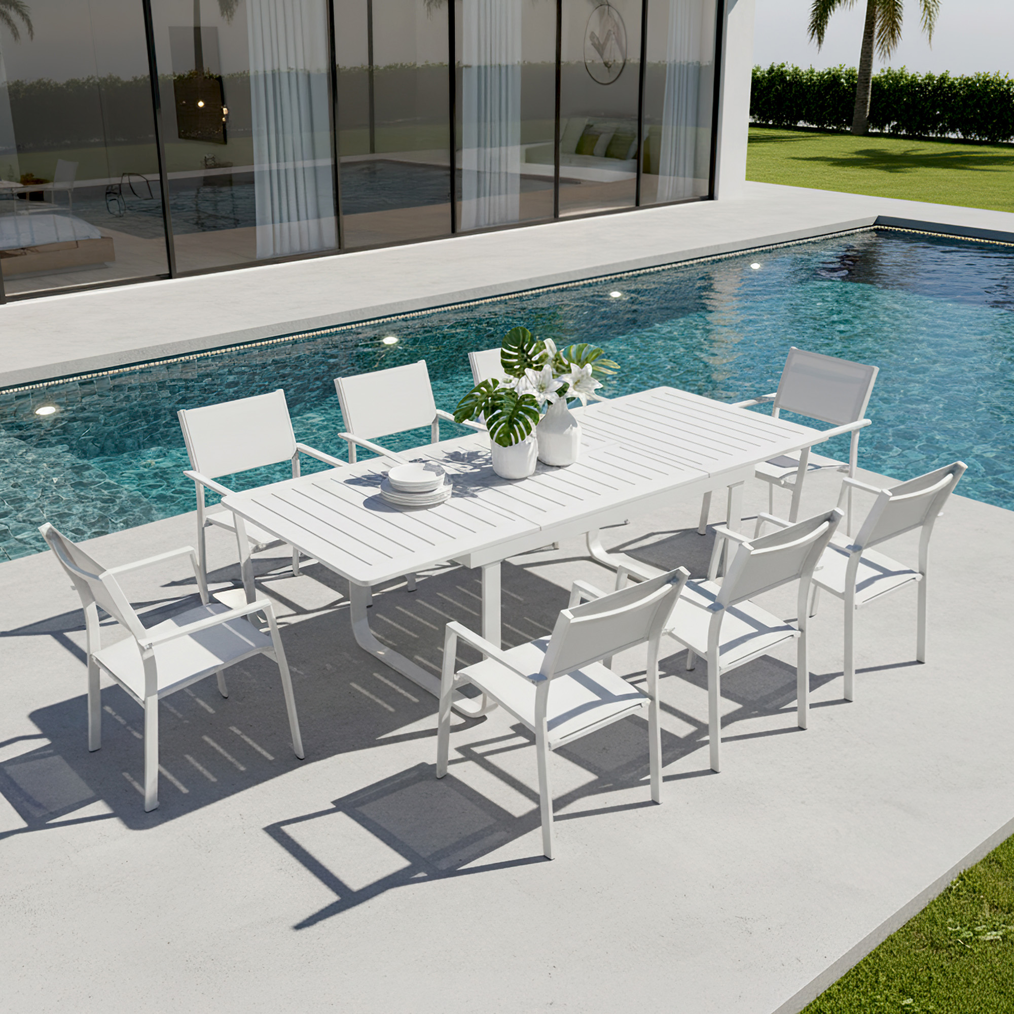 White extendable outdoor dining table with eight matching chairs by a poolside patio-Seehill