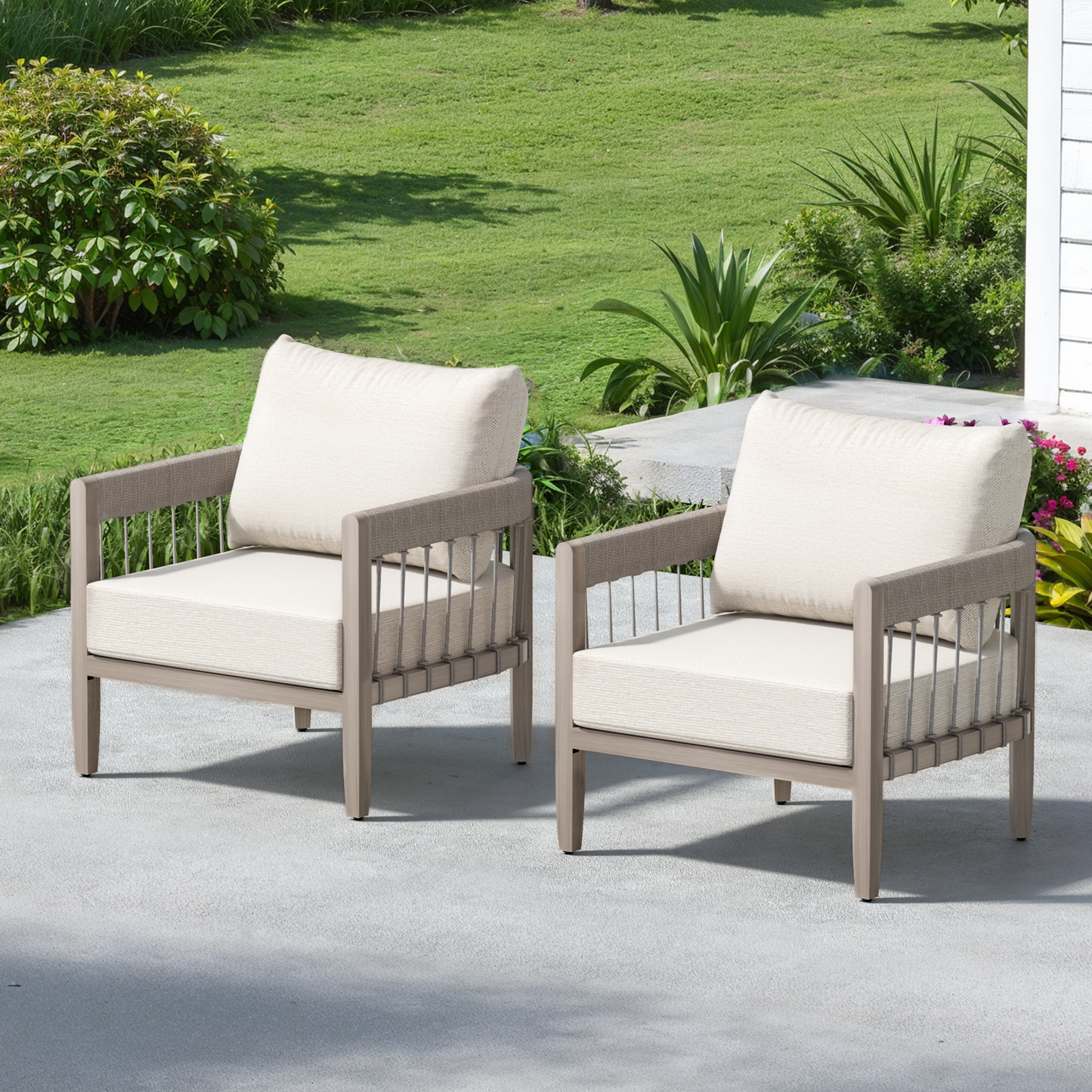 Two cushioned outdoor armchairs with faux wood grain frames on a patio near greenery-Seehill