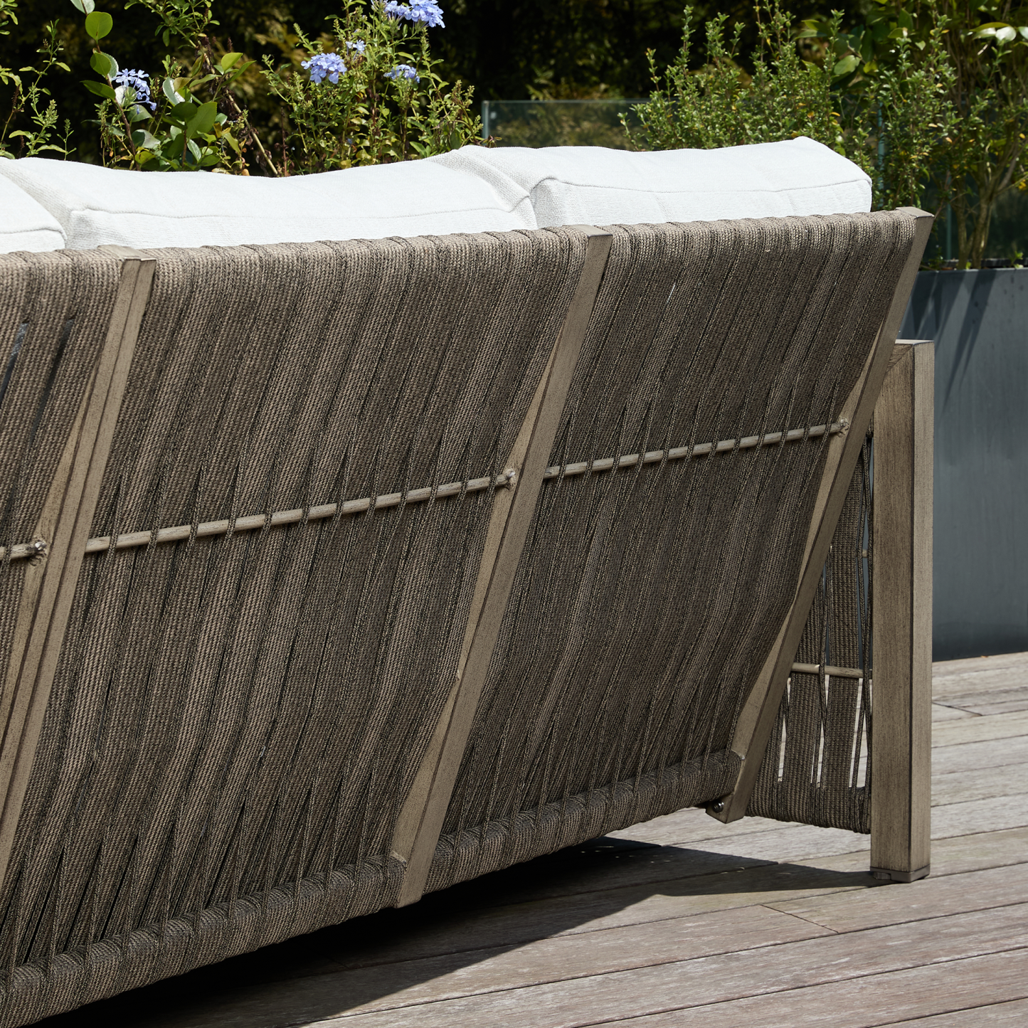 Outdoor wicker sofa with white cushions on deck - Seehill