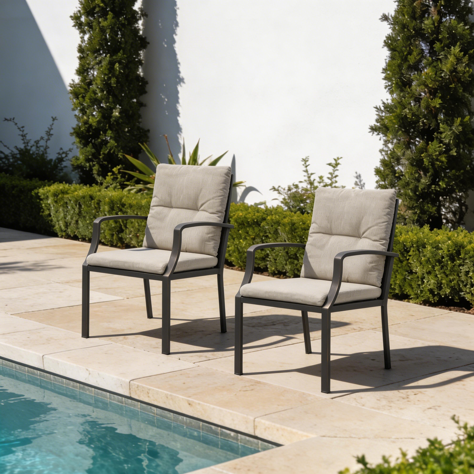 Two cushioned outdoor dining chairs with metal frames beside a pool in a garden setting-Seehill