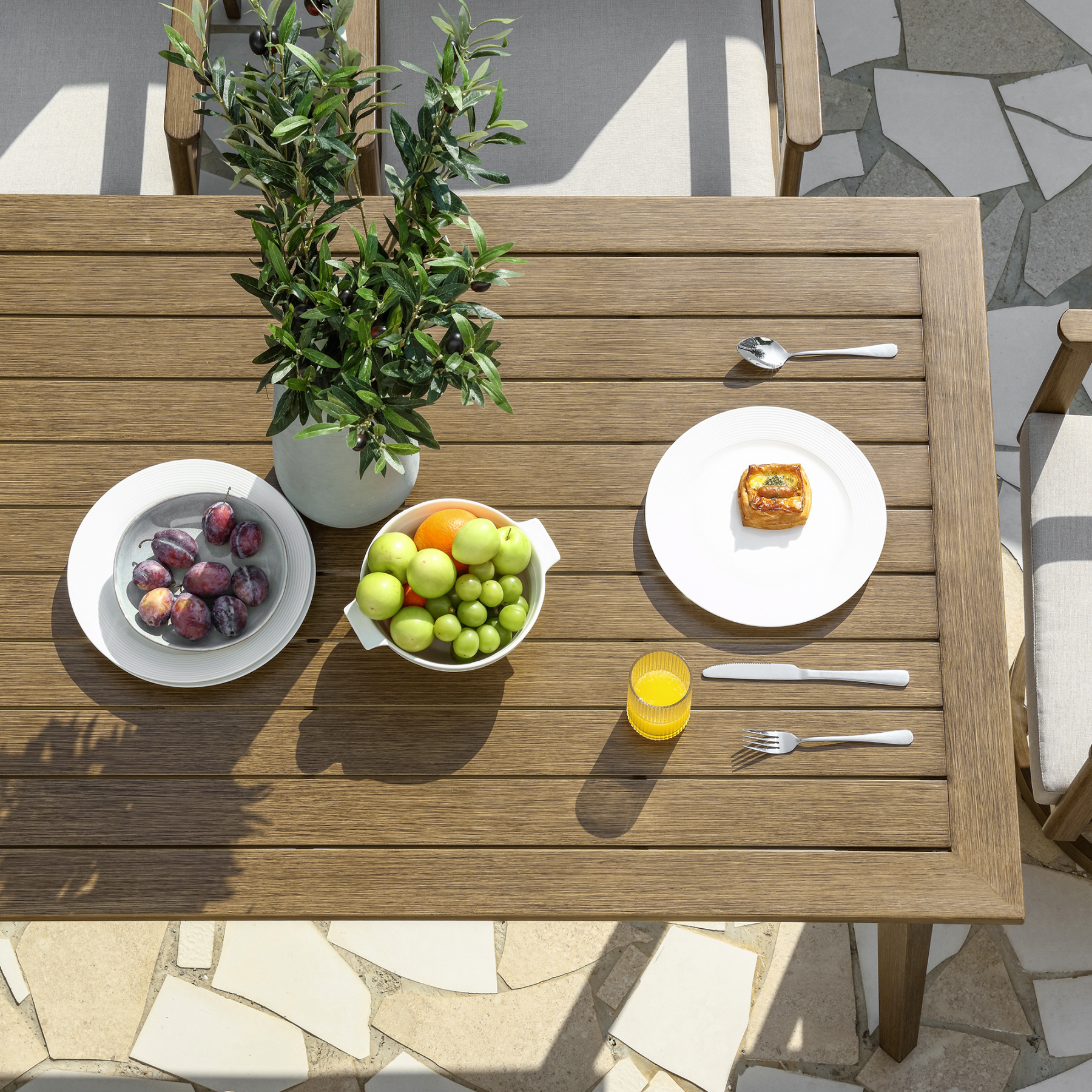 Outdoor wooden dining table with fruit and dishes - Seehill