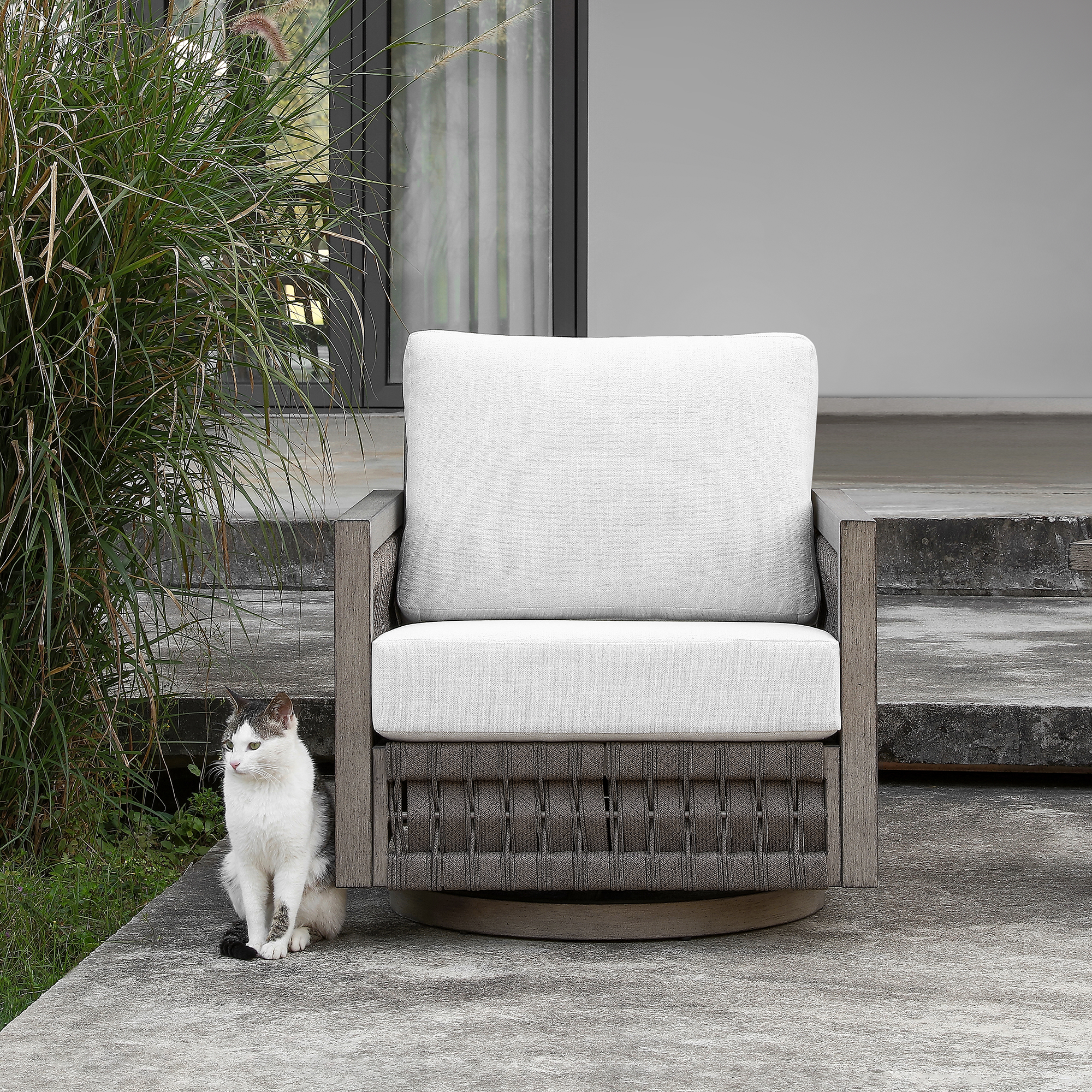An elegant oversize rope weave outdoor swivel sofa paired with an outdoor swivel armchair with light gray cushions completes the set. - Seehill