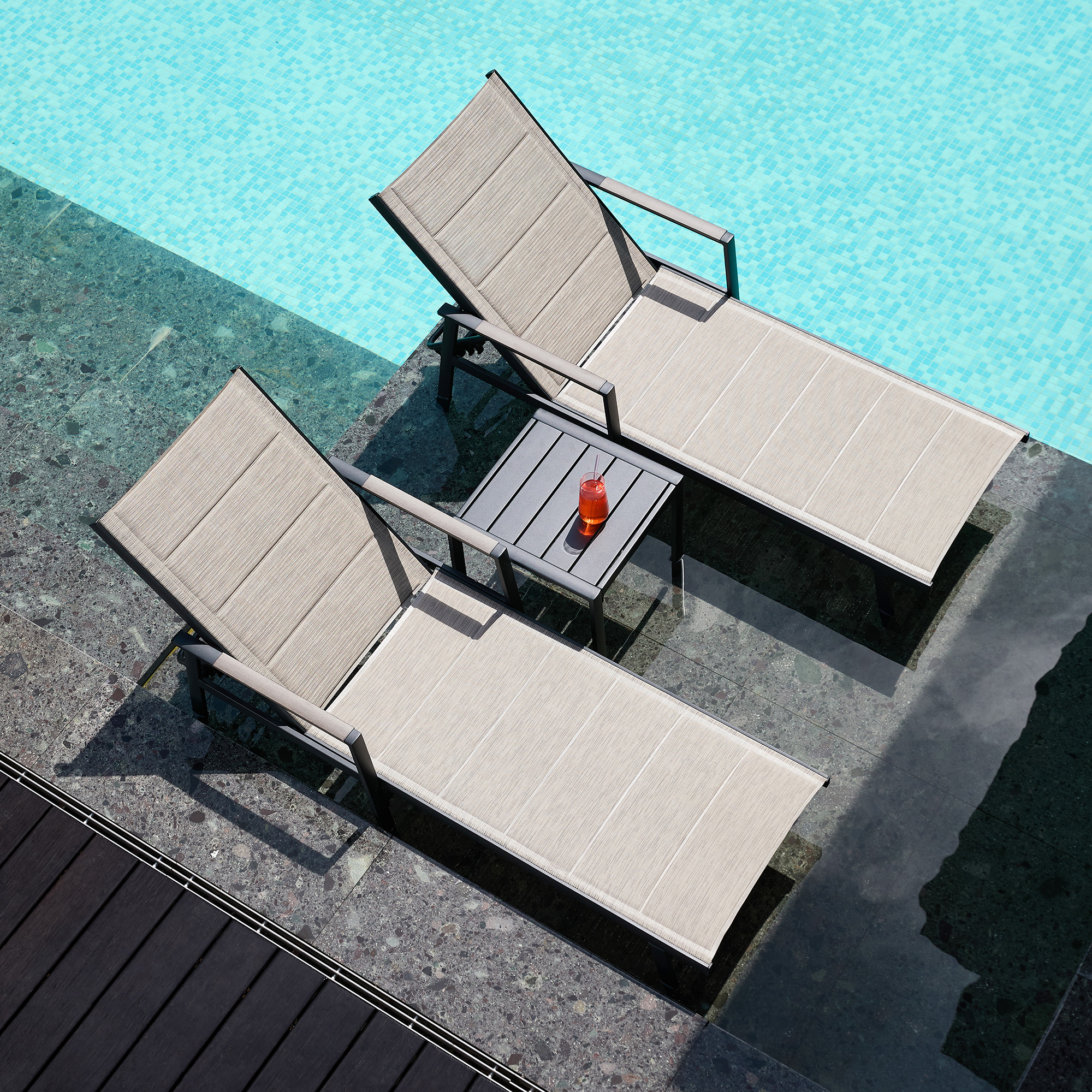 Crafted with beige outdoor lounge chairs and a side table by the pool, this Outdoor Recliner Chair Set offers comfort and elegance. - Seehill