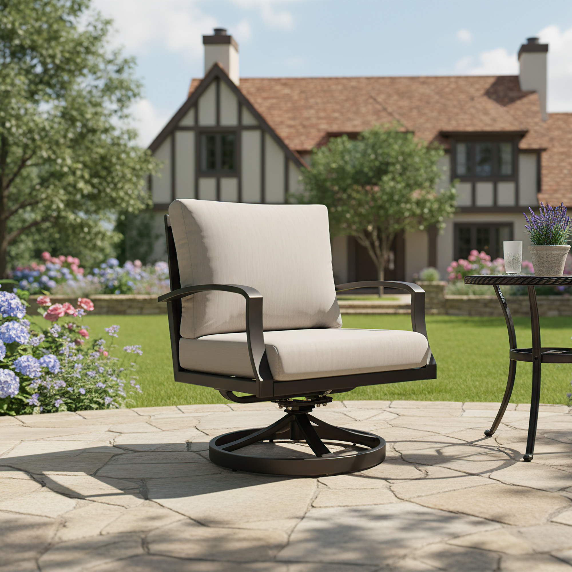Wide cushioned outdoor swivel chair on stone patio with garden and house background -Seehill