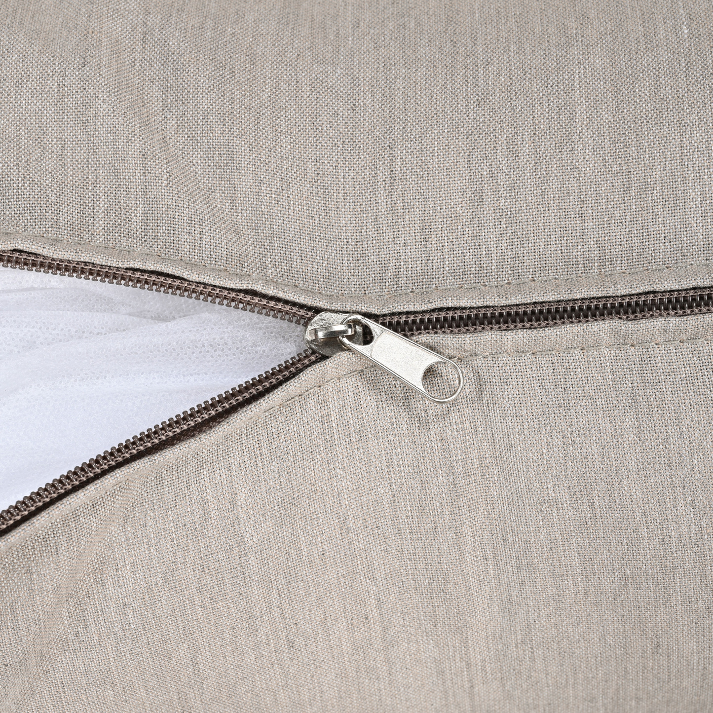 Close-up of a beige fabric cushion cover with a zipper detail for easy removal -Seehill