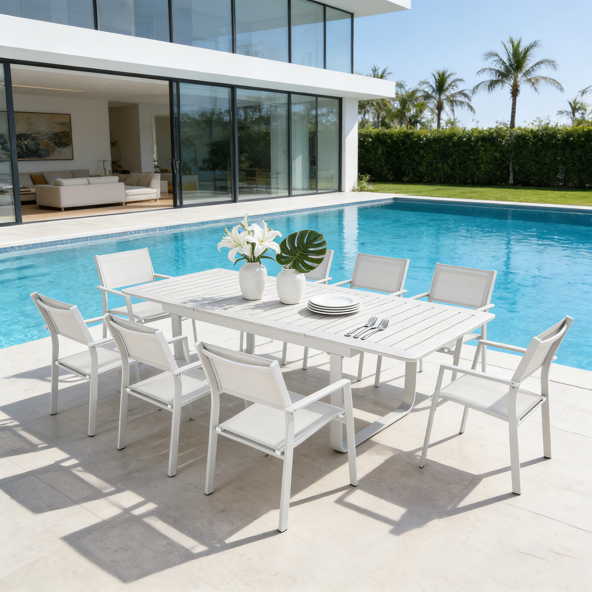 White extendable outdoor dining table with eight matching chairs by the poolside -Seehill