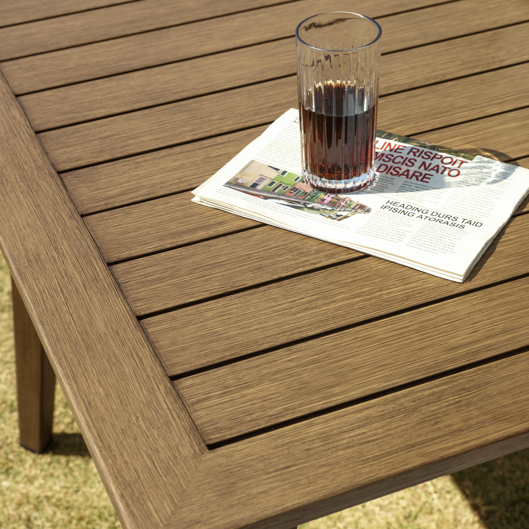 Outdoor wooden table with slatted design and glass of coffee - Seehill