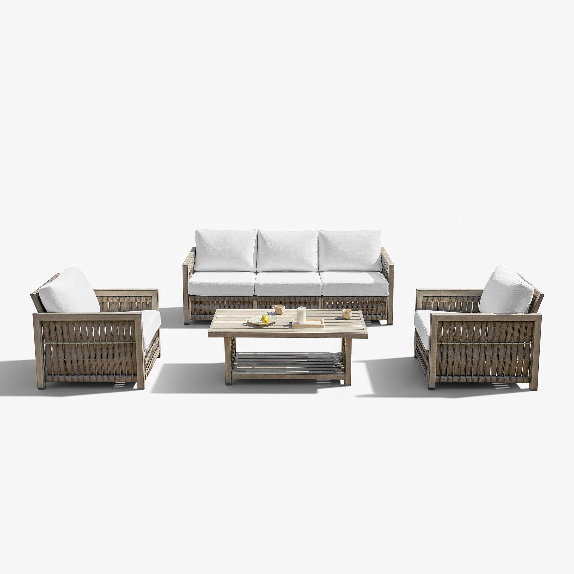 This image highlights the weather-resistant rattan outdoor sofa set with white cushions of this refined outdoor setting. - Seehill