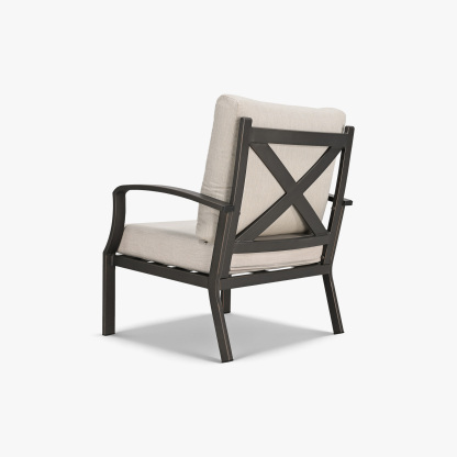 Side view of a deep-seating patio armchair with beige cushions and dark metal frame -Seehill