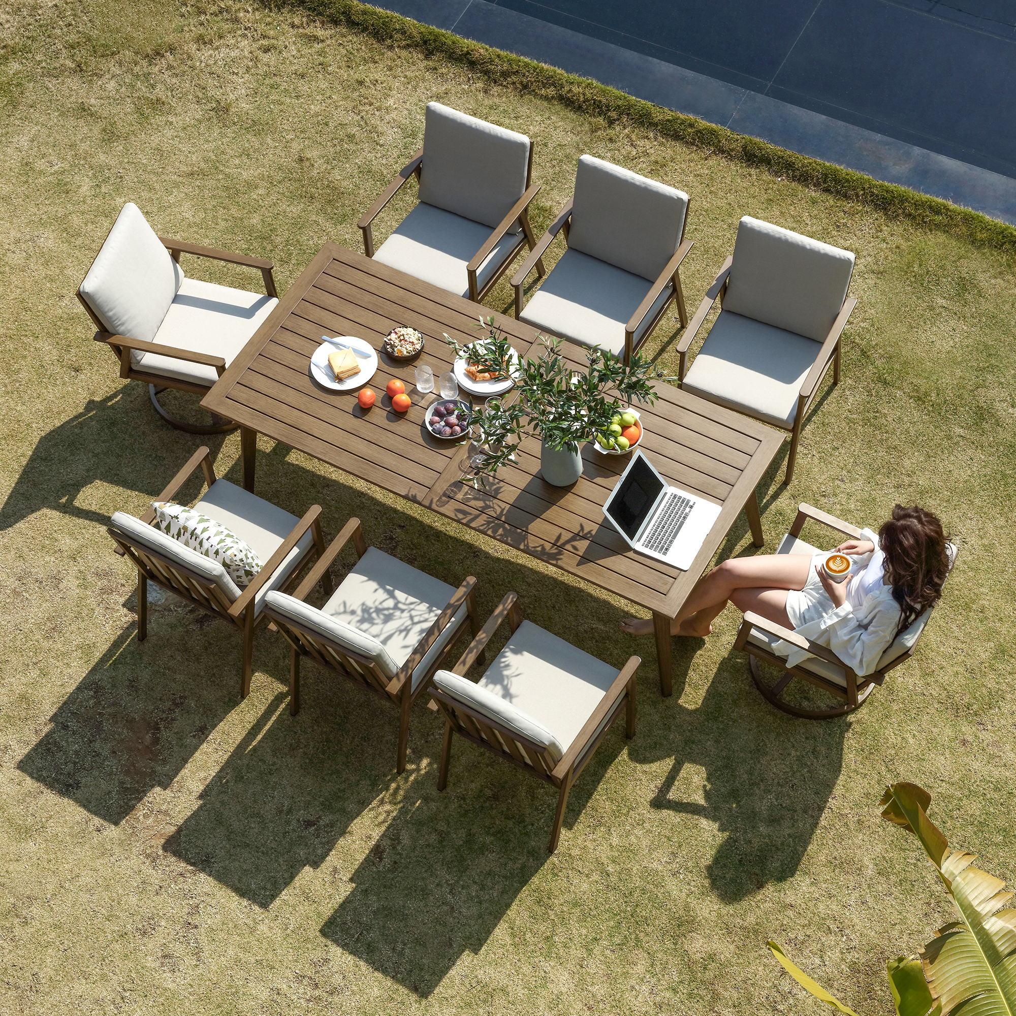 Explore the modern outdoor dining set with a teak wood table and cushioned seating in the graceful outdoor ensemble. - Seehill