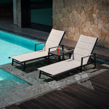 Outdoor lounge chairs with side table by poolside - Seehill