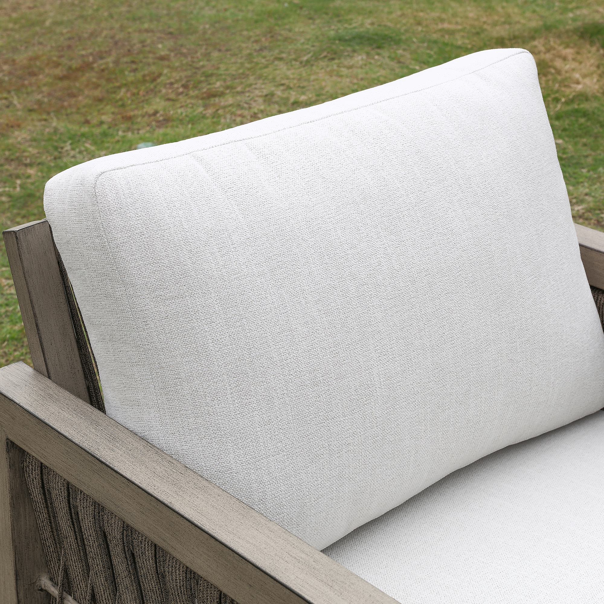 Explore the outdoor gray cushion on a wooden patio chair, made of durable fabric for the graceful Oversize Rope Weave Outdoor Sofa. - Seehill