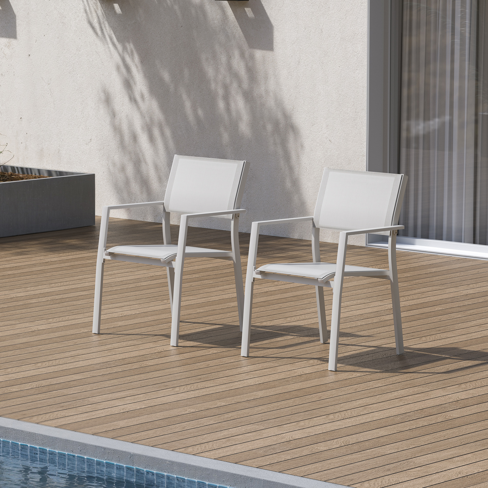 Two white stackable patio dining chairs with textile seats on a wooden deck by the pool -Seehill