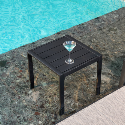Black outdoor side table with drink by pool, modern design - Seehill