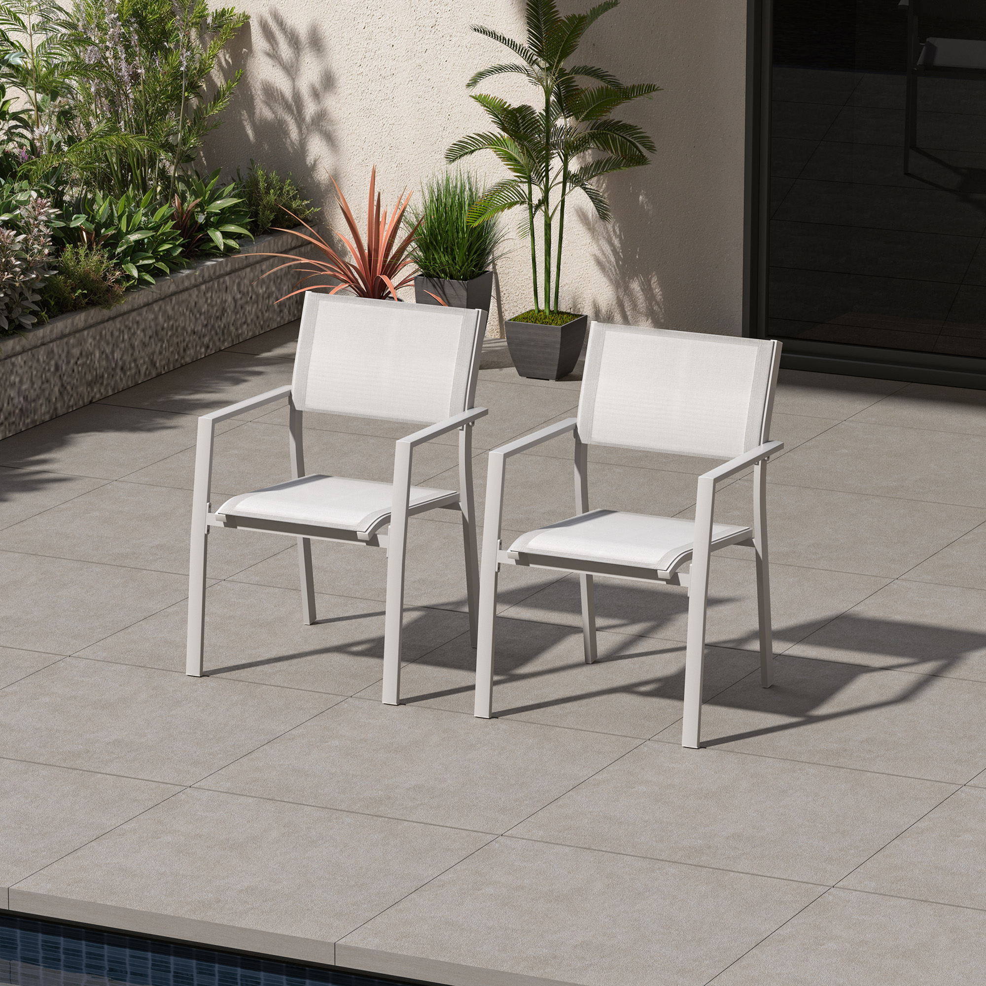 Two white stackable patio dining chairs with textile seats on a tiled outdoor patio showing-Seehill