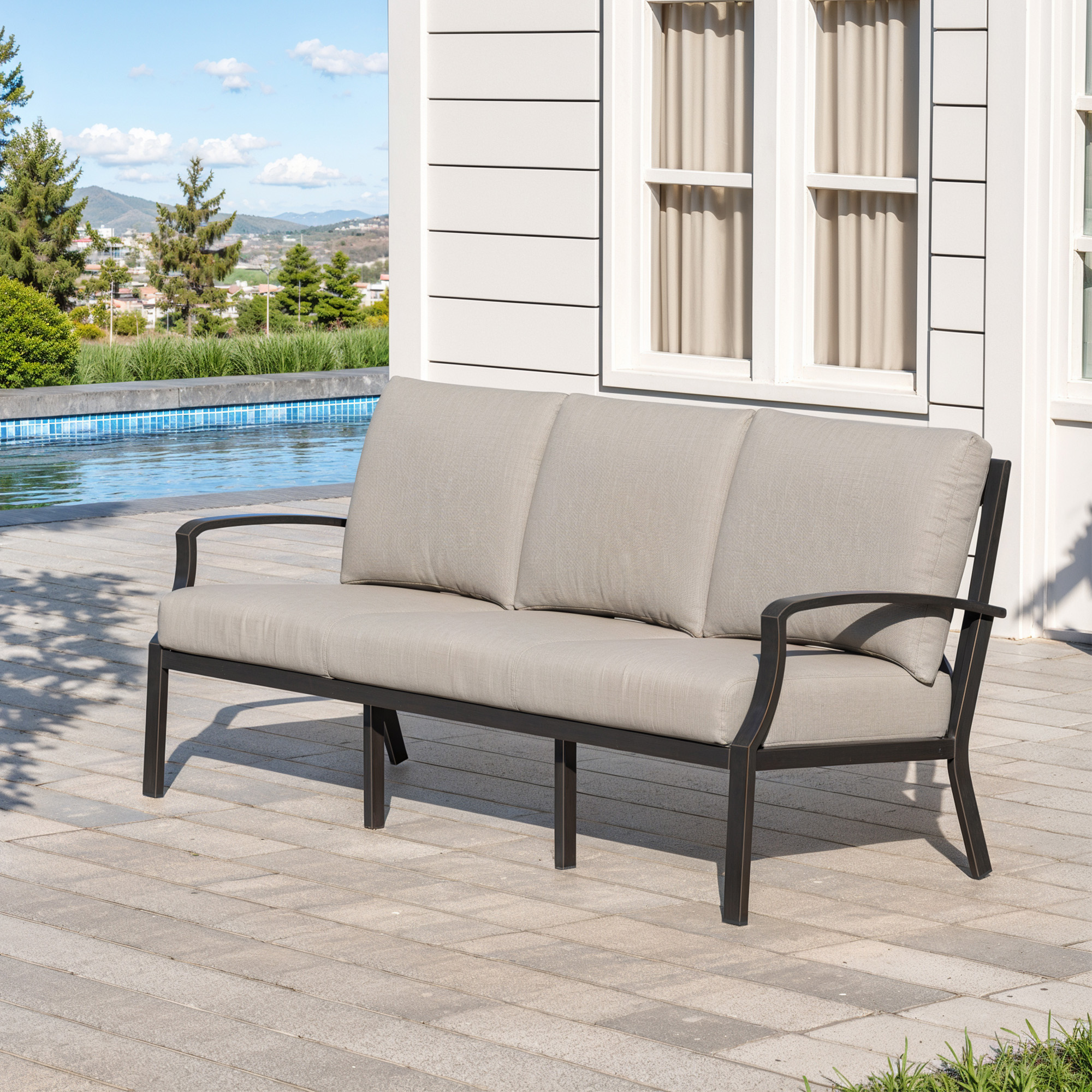 Spacious three-seat outdoor sofa with neutral cushions set on a patio near a pool -Seehill
