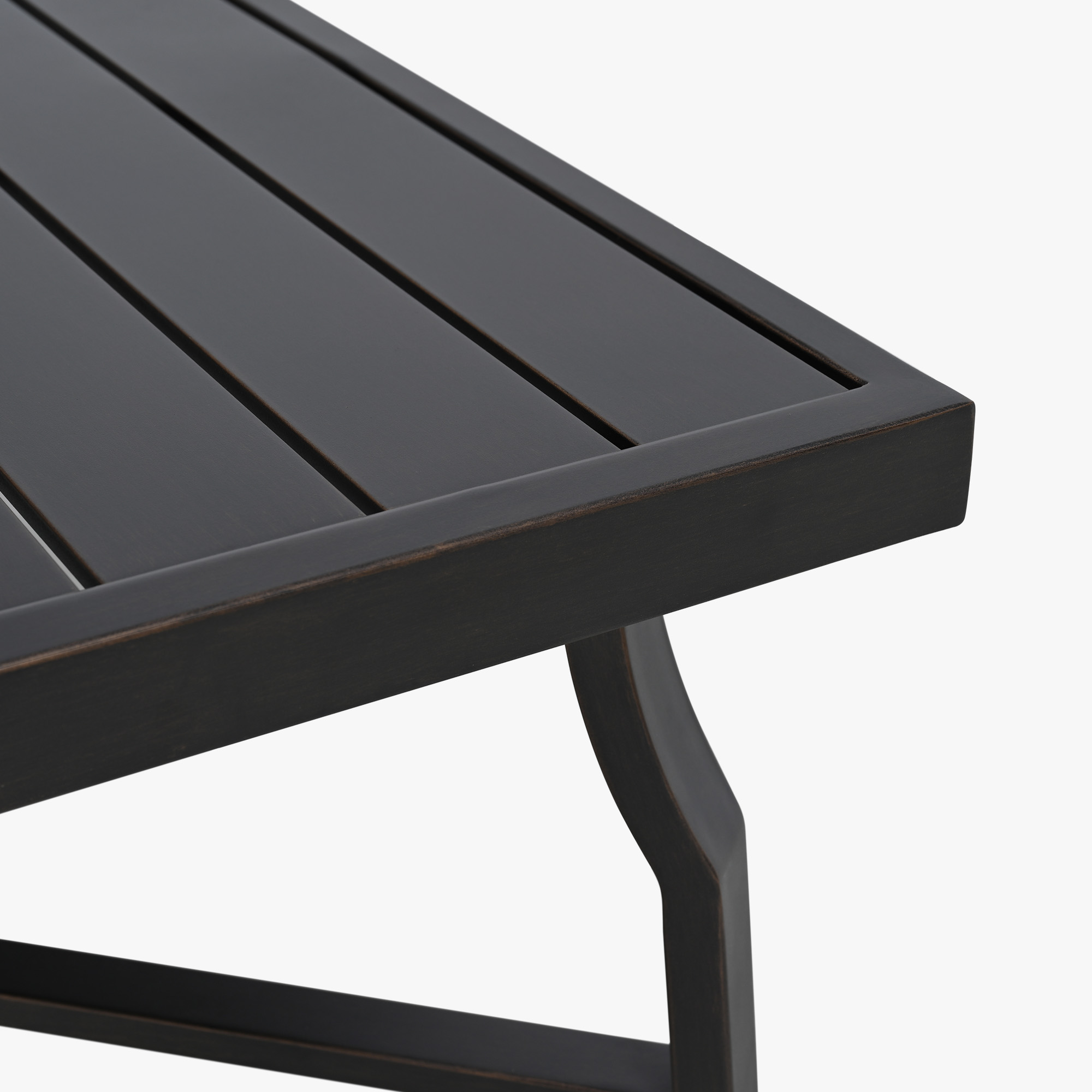 Close-up of dark metal outdoor coffee table with slatted top and curved leg detail-Seehill