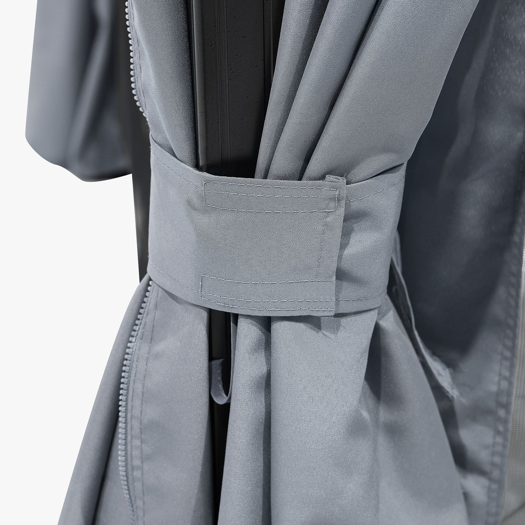 Close-up of gray fabric tie holding back curtain on outdoor patio gazebo frame -Seehill