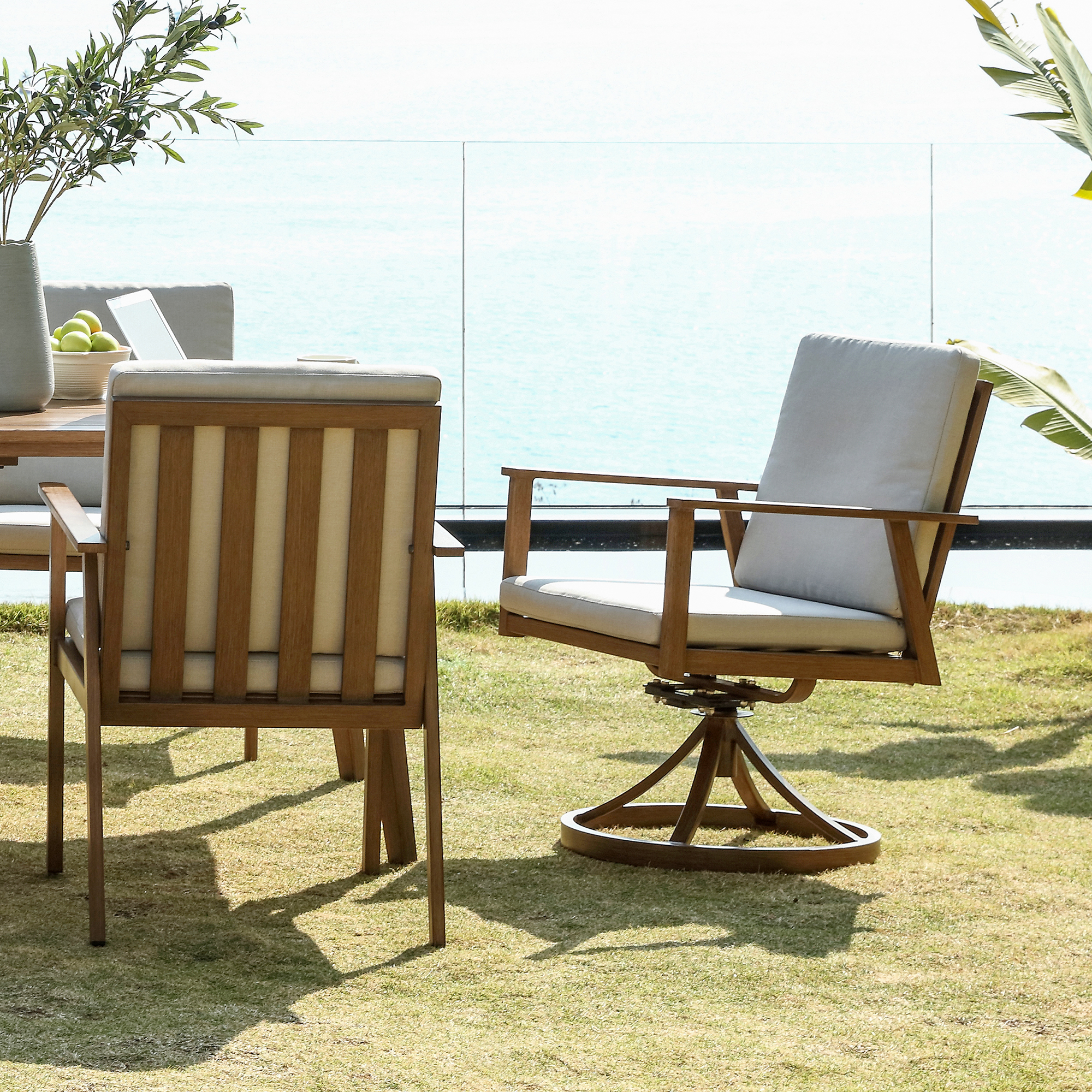 Crafted with an outdoor wooden swivel chair with cushion, this modern patio furniture piece is both stylish and comfortable. - Seehill